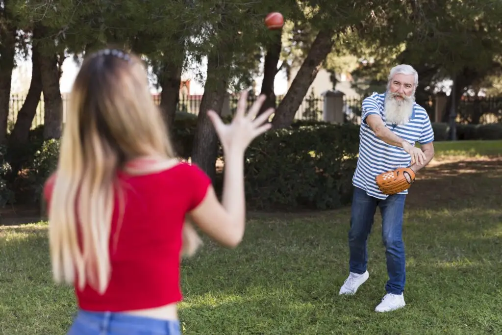 Father and daughter playing catch with a baseball